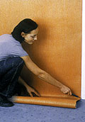 При наклейке обоев на флизелиновой основе клей наносится на стену (IDECO)